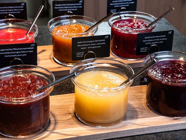 Barattoli di marmellate fatte in casa su un tagliere di legno