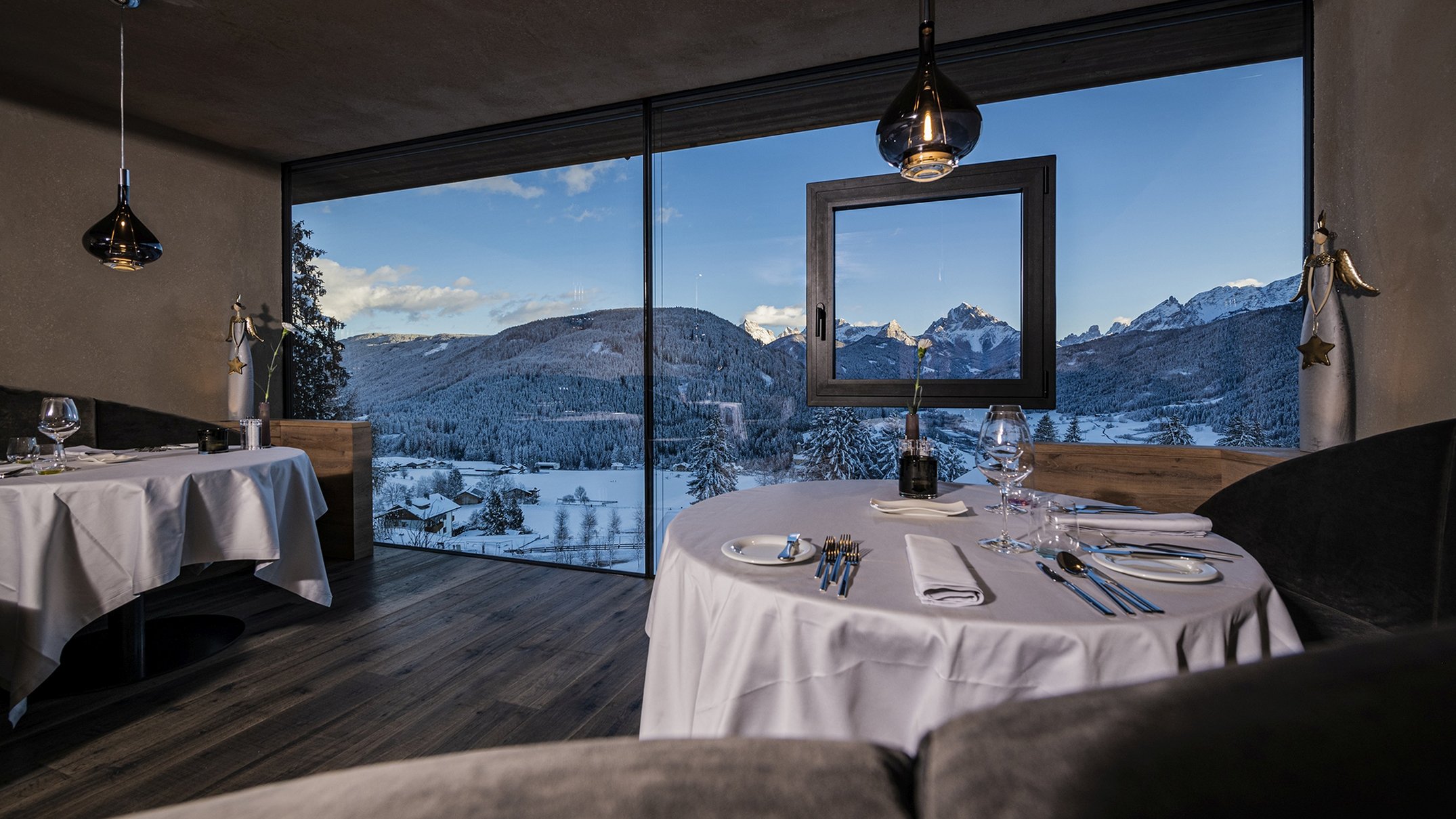 Alpen Tesitin: Ihr Gourmethotel in Südtirol Elegantes Restaurant mit Rundtisch und Blick auf schneebedeckte Berge