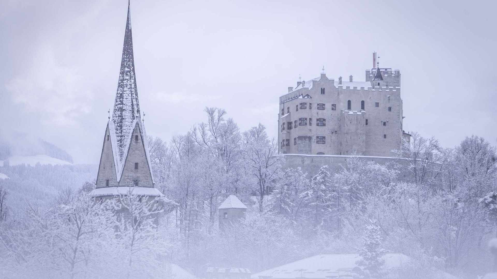 Castle and church in snowy winter forest