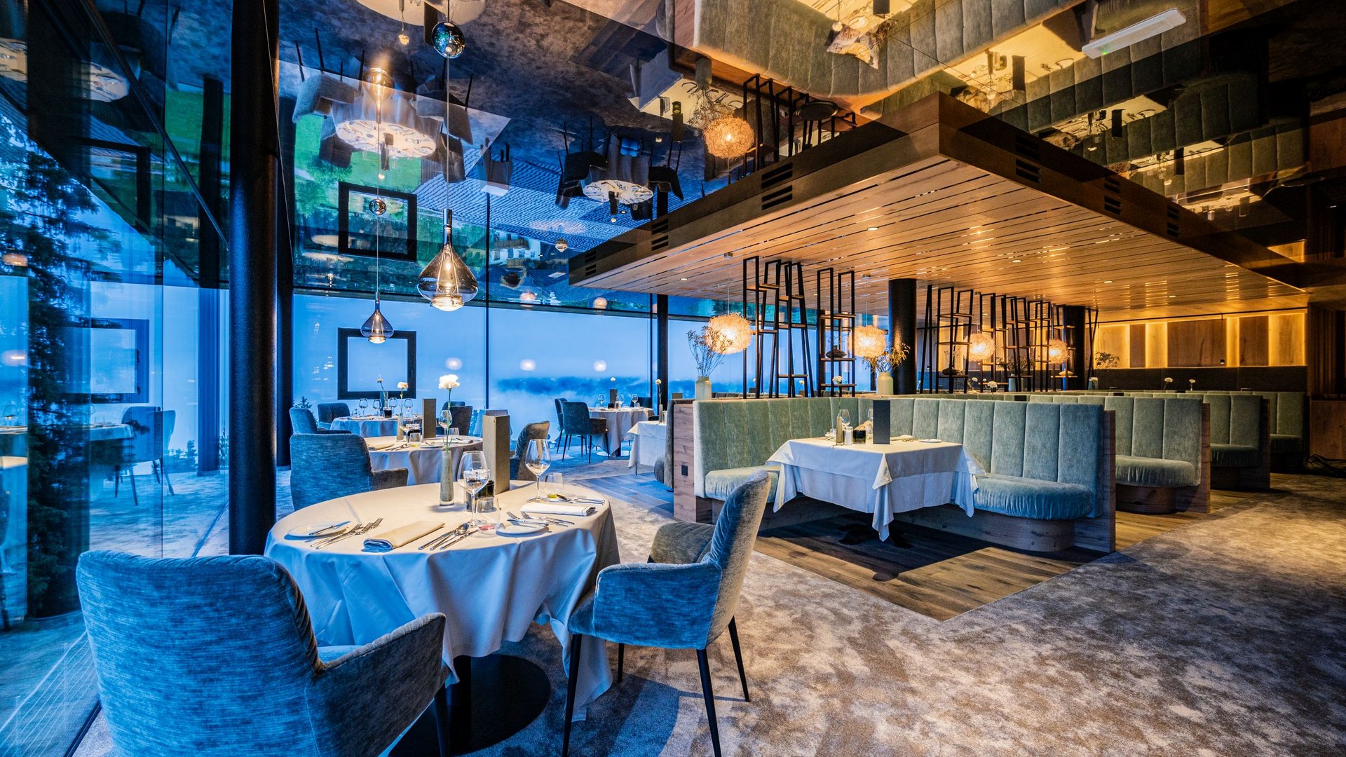 Modernes Restaurant mit blauen Stühlen und großen Fenstern mit Aussicht