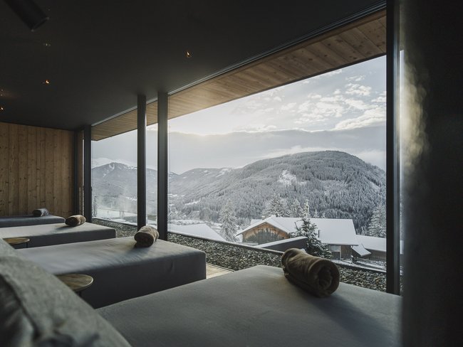 Lounge beds with rolled towels overlooking snowy mountain landscape