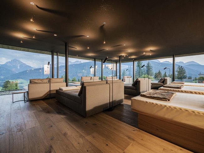 Modern lounge with comfortable sofas and panoramic mountain and forest view