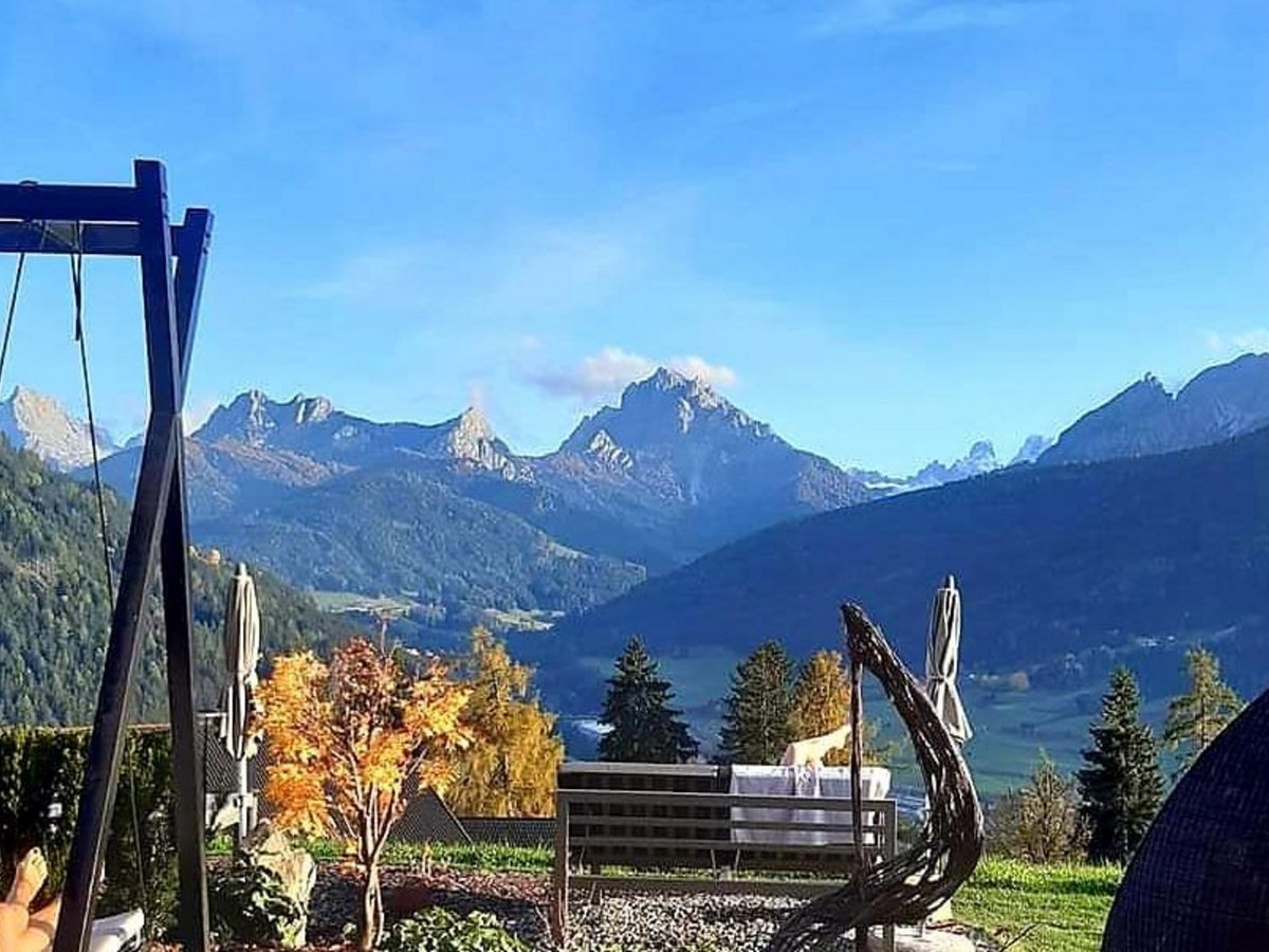 Alpen Tesitin: ecco cosa dicono i nostri ospiti Terrazza accogliente con altalena e vista sulle montagne sotto un cielo limpido
