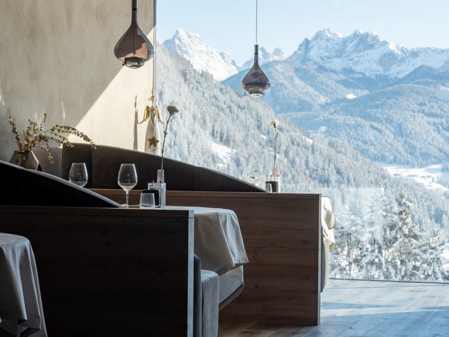Restaurant mit Tischen und Blick auf verschneite Berglandschaft