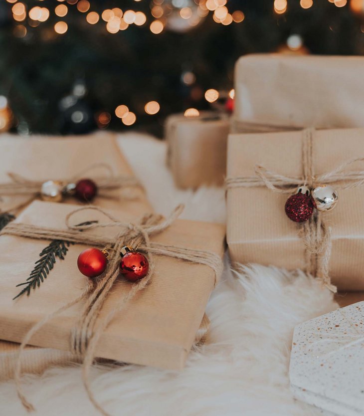 Your 5-star hotel in Val Pusteria/Pustertal: Alpen Tesitin Christmas gifts wrapped in brown paper with red and silver ornaments under tree