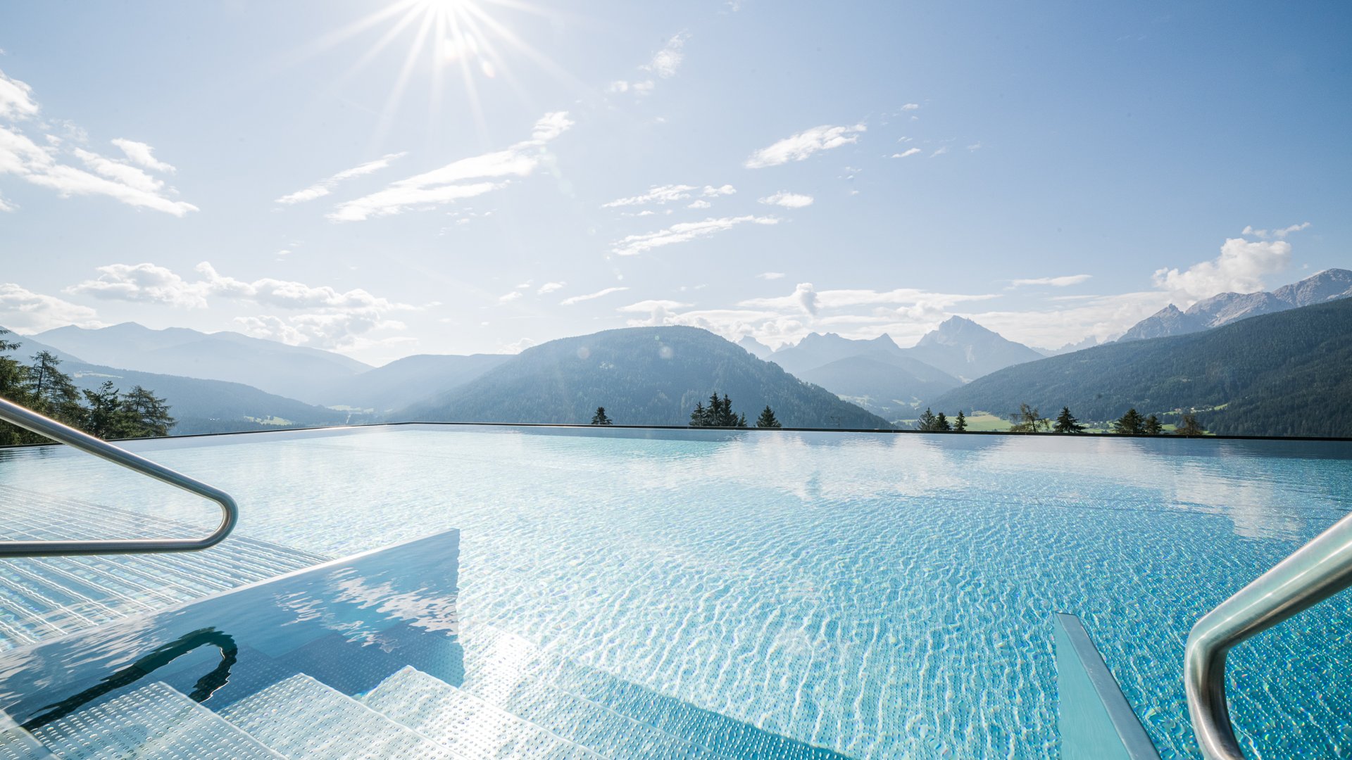 Piscina a sfioro con vista sulle montagne sotto il sole