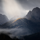Berglandschaft mit Nebel und Sonnenlicht auf bewaldetem Hügel