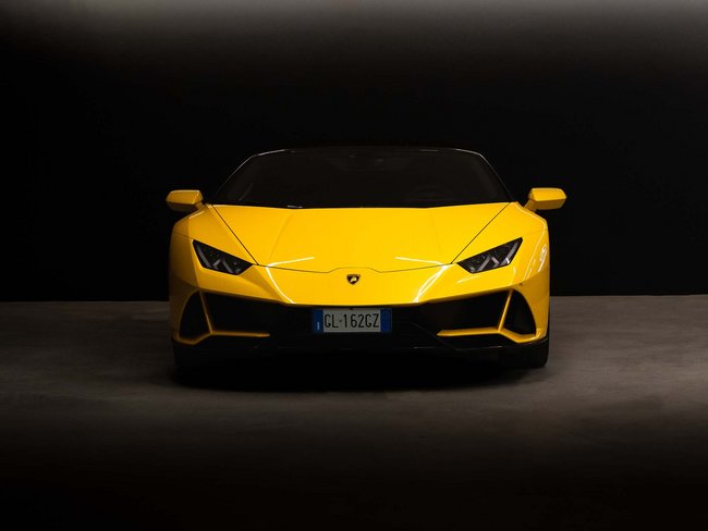 Gelber Lamborghini Sportwagen von vorne im dunklen Raum