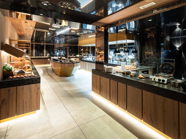 Sala colazione moderna con buffet e piastra per waffle