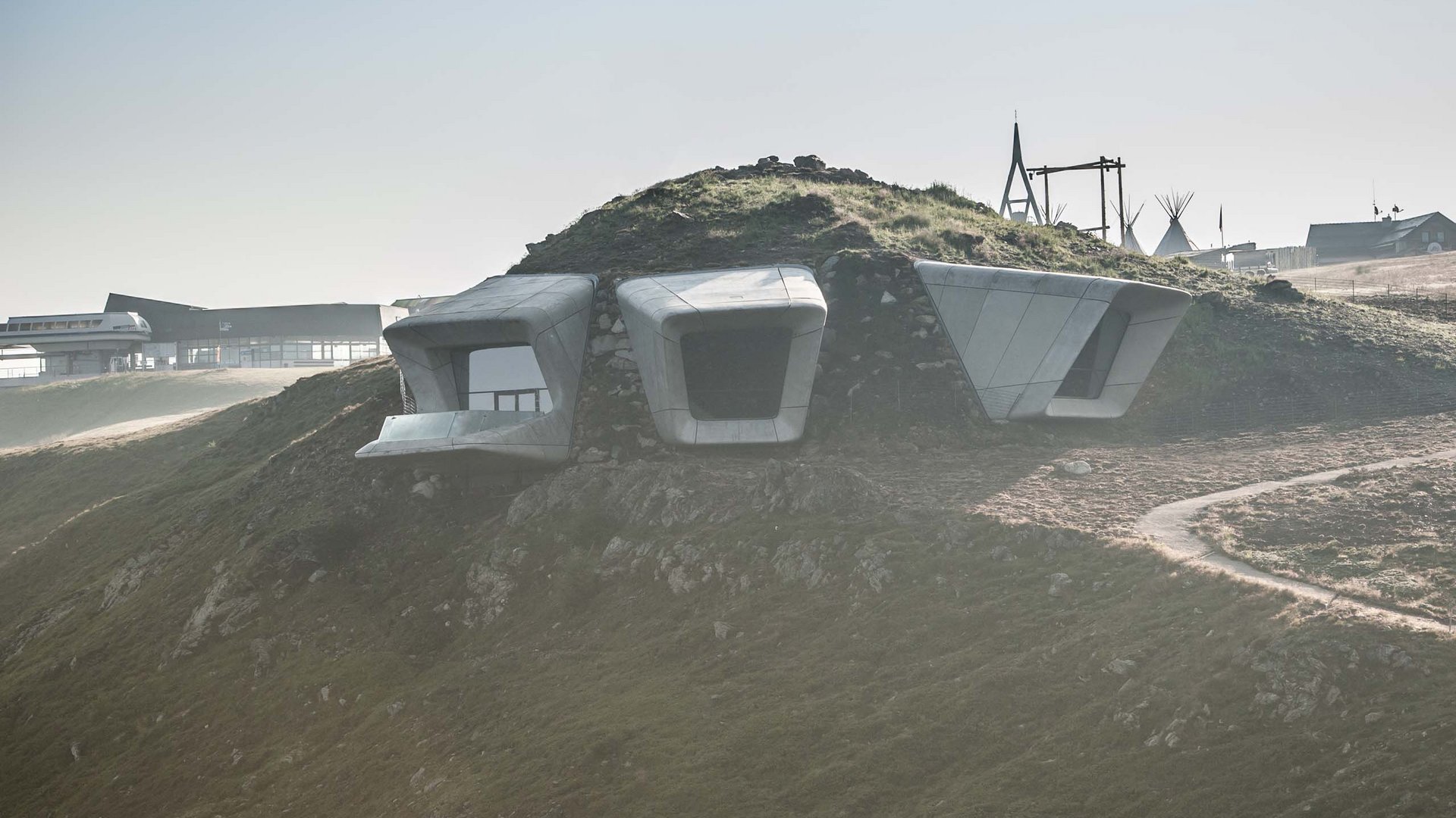 Modern concrete structures on a grassy sloped hill