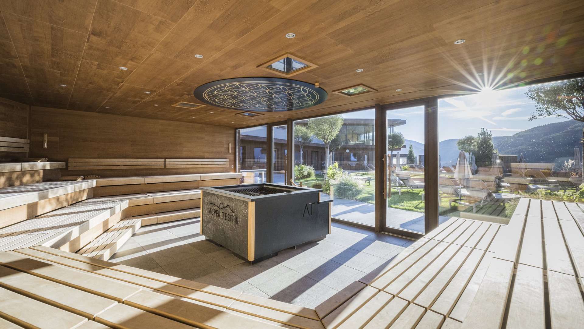 Sauna luminosa con rivestimento in legno e grandi finestre con vista sulle montagne
