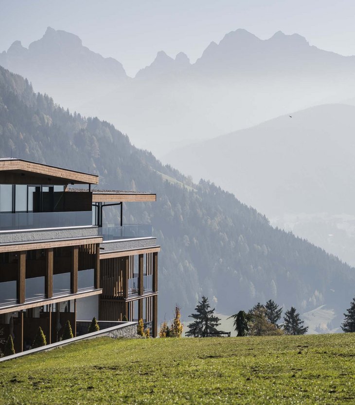 Building on green hill with misty mountains in the background