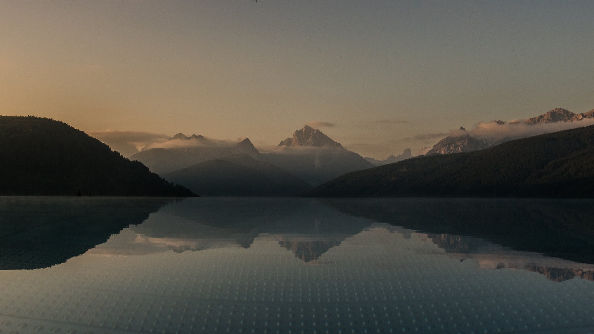 Your hotel in Val Pusteria/Pustertal with pool oasis Mountain lake at sunset reflecting the surrounding mountains