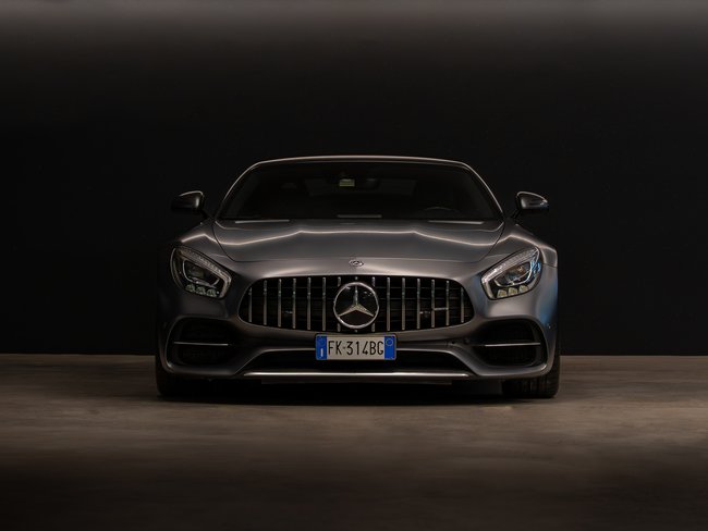 Front view of a gray Mercedes sports car against a black background