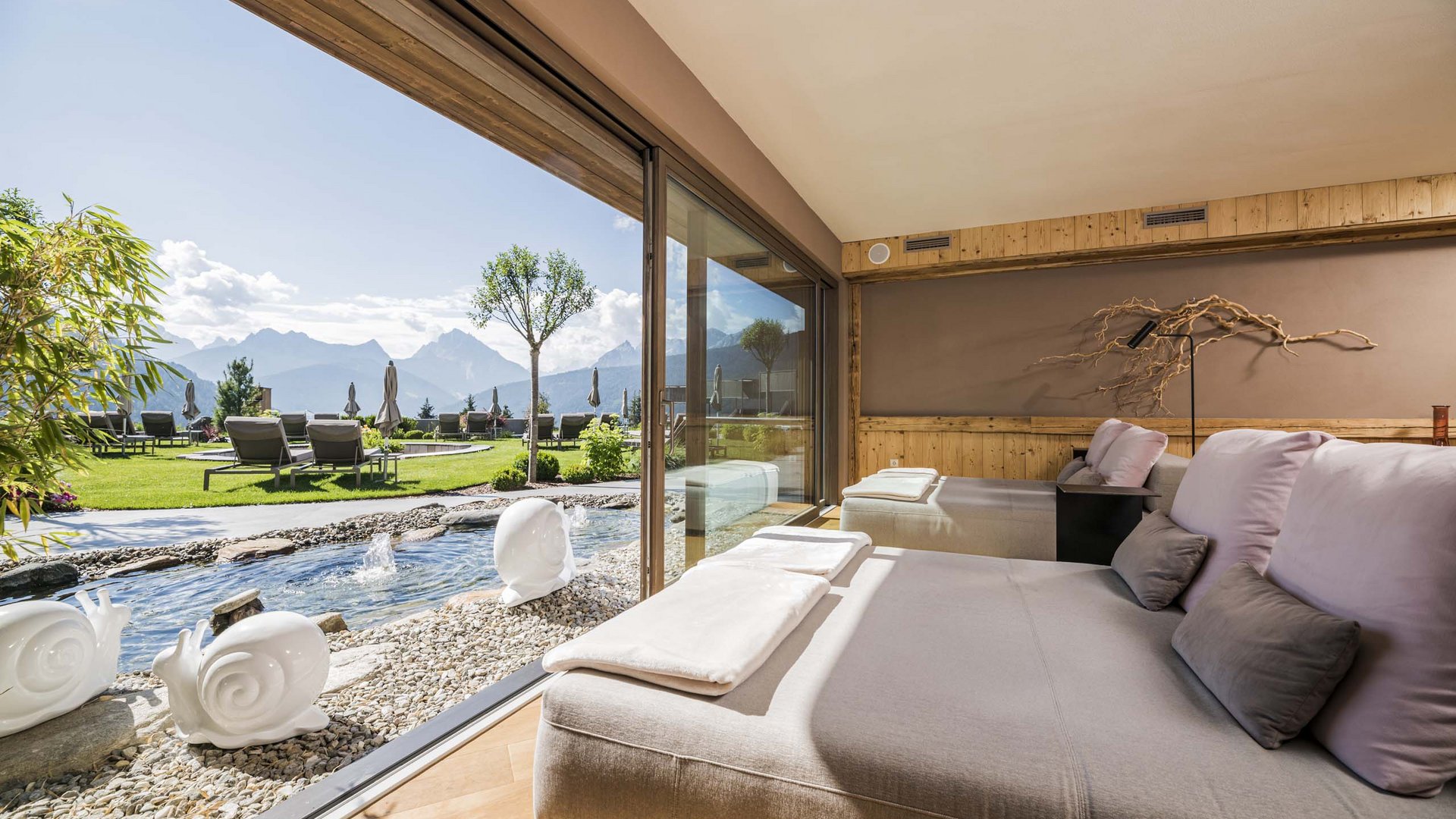 Lounge confortevole con vista su giardino, montagne e fontana d'acqua