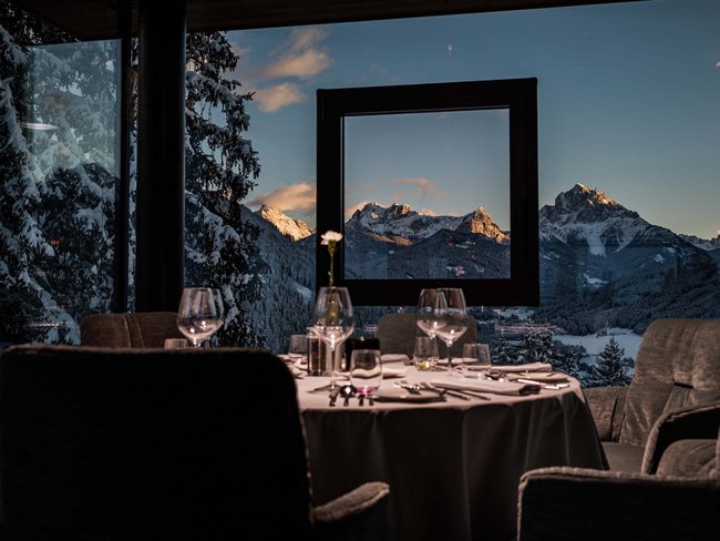 Restaurant mit gedecktem Tisch und Blick auf schneebedeckte Berge