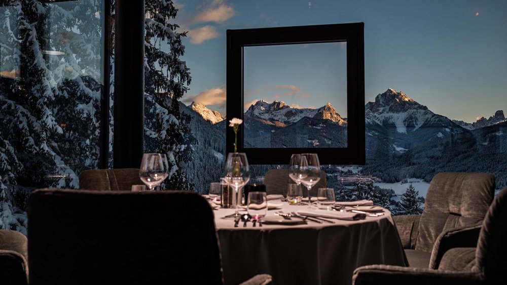 Restaurant mit gedecktem Tisch und Blick auf schneebedeckte Berge