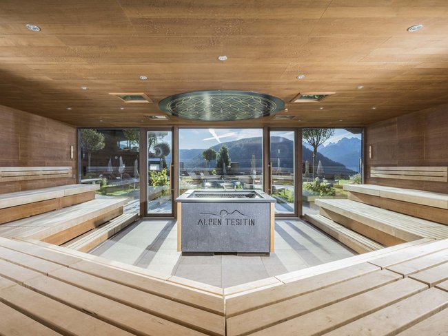 Sala sauna moderna in legno con vista su montagne e giardino