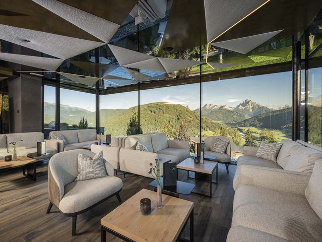 Soggiorno moderno con grandi finestre e vista sulle montagne