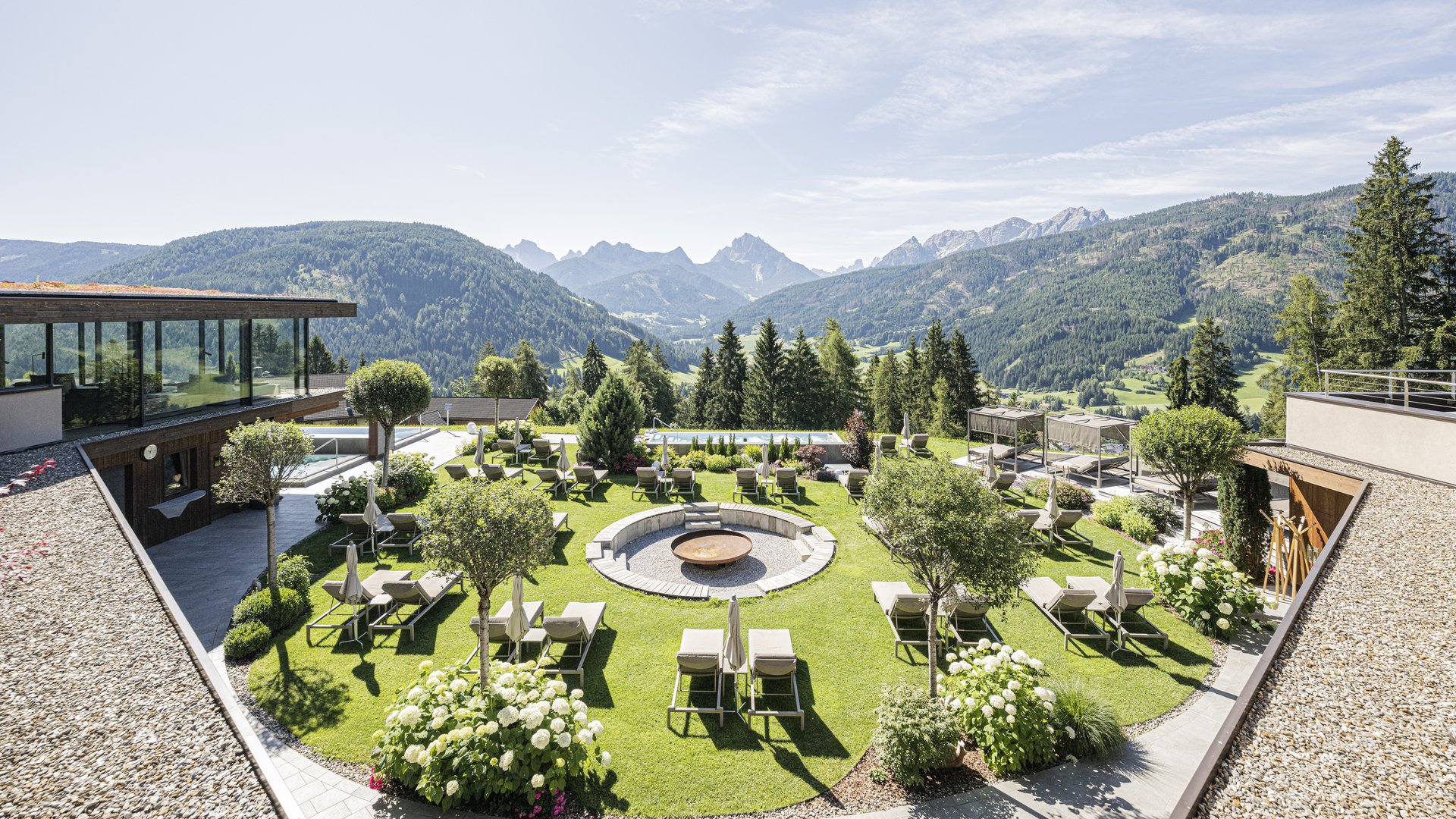 Alpen Tesitin: il vostro hotel con spa tra le Dolomiti Giardino curato dell’hotel con lettini e panorama montano