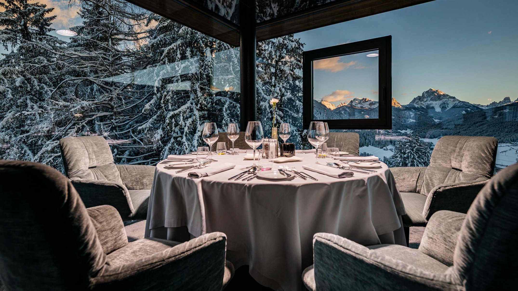 Your 5-star hotel in Val Pusteria/Pustertal: Alpen Tesitin Elegant dining room with round table and view of snowy mountains