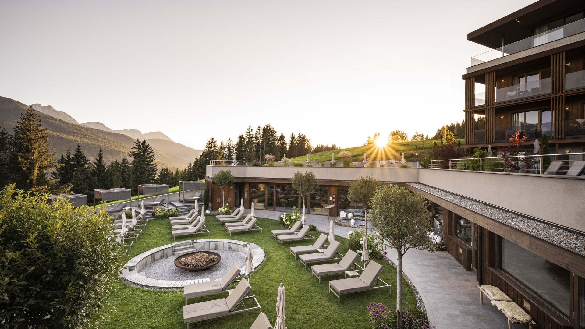 Hotel con lettini e tramonto tra le montagne