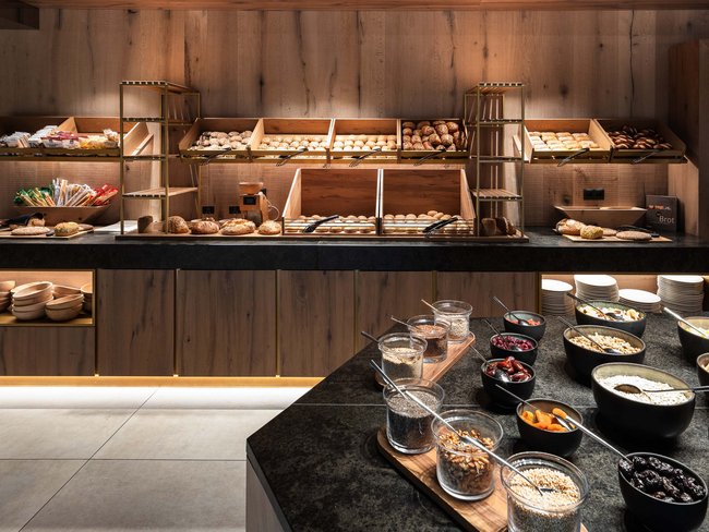 Buffet con vari tipi di pane e cereali in ciotole in ambiente moderno
