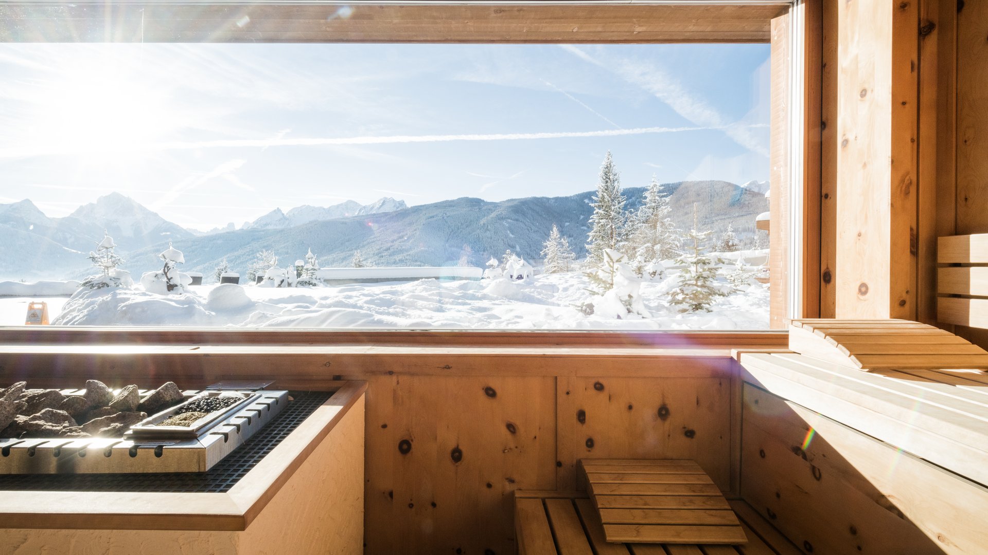 Hotel con sauna in Alto Adige:l’Alpen Tesitin Sauna in legno con vista su montagne innevate e cielo soleggiato