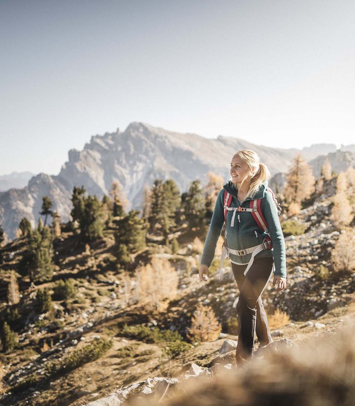 Zwei wandern in den Bergen bei klarem Himmel und herbstlicher Landschaft