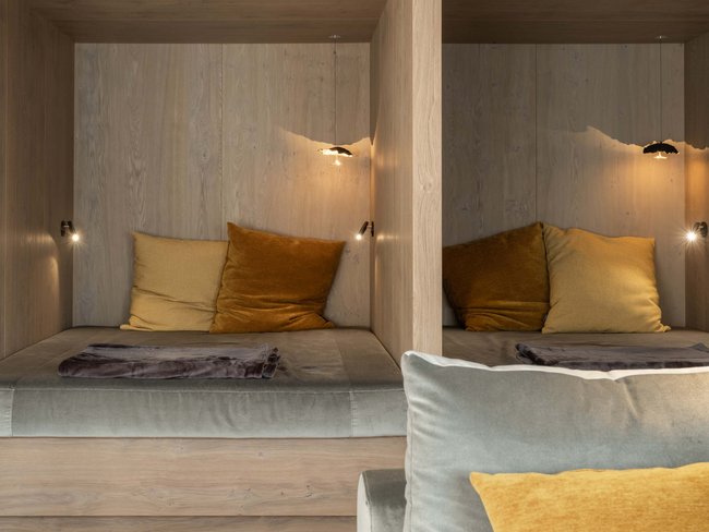 Cozy nook with pillows and soft blanket in wooden wall surroundings