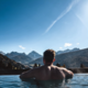 Alpen Tesitin: das sagen unsere Gäste Mann entspannt im Pool mit Blick auf Berglandschaft unter blauem Himmel