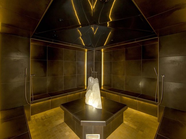 Sala vapore moderna con cristallo illuminato al centro e pareti marroni