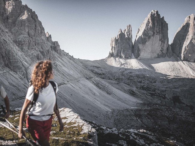 5-Sterne-Sporthotel in Südtirol gesucht? Wanderer vor den markanten Drei Zinnen in den Dolomiten