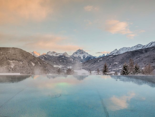 Hotel con vasca idromassaggio in camera in Trentino-Alto Adige Piscina riscaldata con vista sulle montagne innevate al tramonto