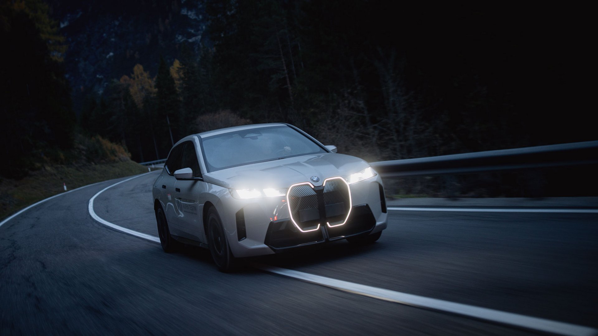 Car rental in Val Pusteria/Pustertal, Dolomites White car with illuminated grille driving at night on winding road