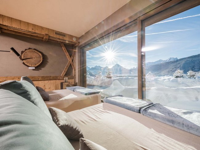 Lettini accoglienti con vista su montagne innevate e sole splendente